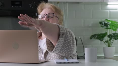 elderly woman finished work, closing laptop happy with work done