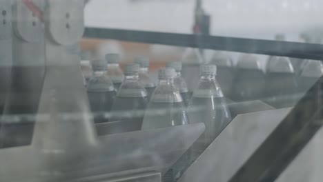 cinta transportadora con botellas de agua potable en una planta de bebidas moderna
