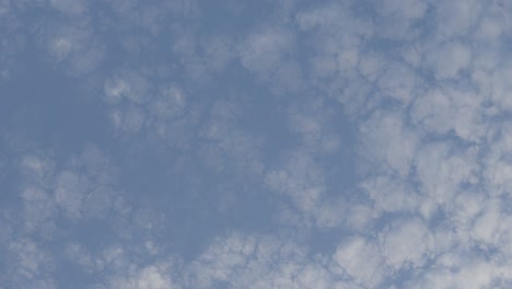 Large-blue-sky-speckled-and-dotted-with-mushroom-like-clouds-broken-through-sky,-time-lapse