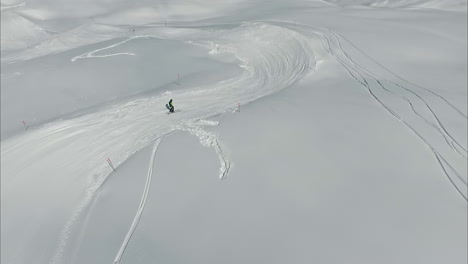 people skiing down track in snow wonderland, aerial drone view