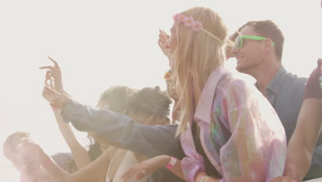 grupo de jóvenes amigos bailando detrás de una barrera en un festival de música al aire libre