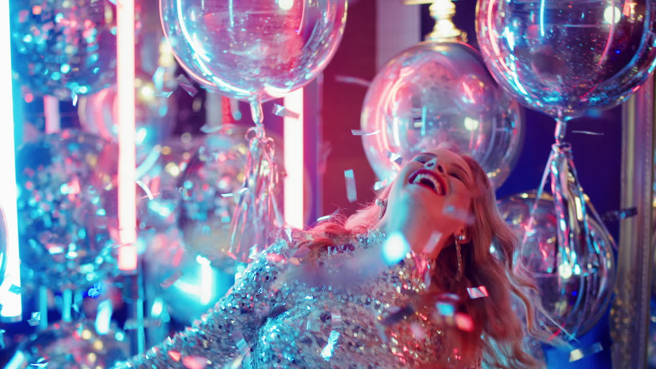 네온 램프의 배경에서 재미를 느끼는 매력적인 소녀. 파티에서 점프하는 여자.