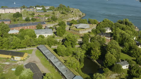 Aerial-view-over-the-Suomenlinna-fortress-island,-sunny,-summer-day,-in-Helsinki,-Finland---reverse,-tilt-down,-drone-shot