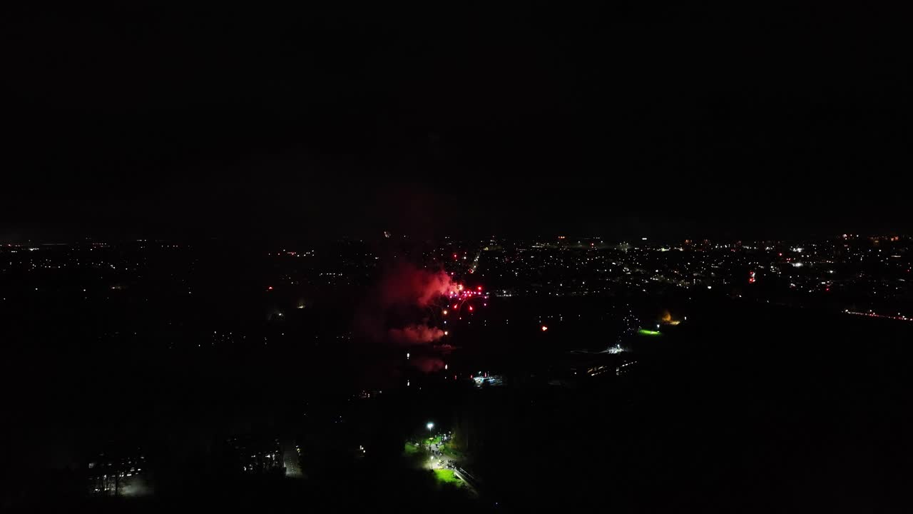 disparo aéreo de pequeños fuegos artificiales rojos que explotan por la noche
