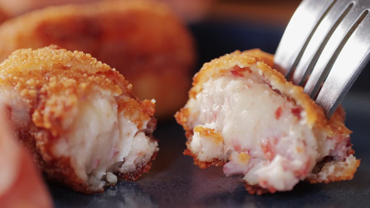Spanish tapas, Fried portuguese croquettes close-up macro. Breaded croquette of fish, potatoes and ham. Man cooking spanish food.