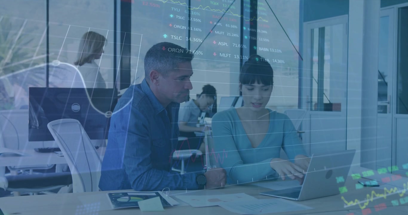 Colegas de negocios analizando datos financieros en portátil en oficina moderna