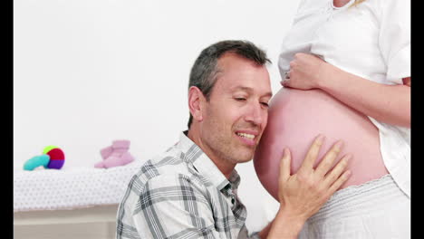 Man-listening-belly-of-his-pregnant-wife