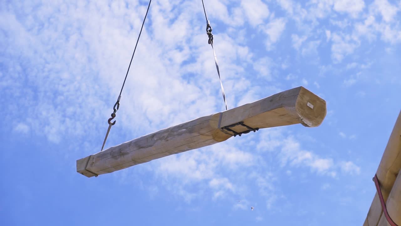 나무로 된 집을 짓기 위해 나무 을 들어 올리는 크레인