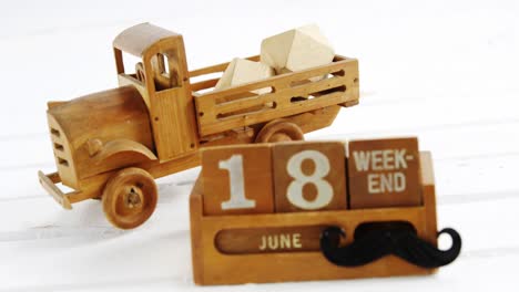Toy-truck-with-date-block-arranged-against-white-background