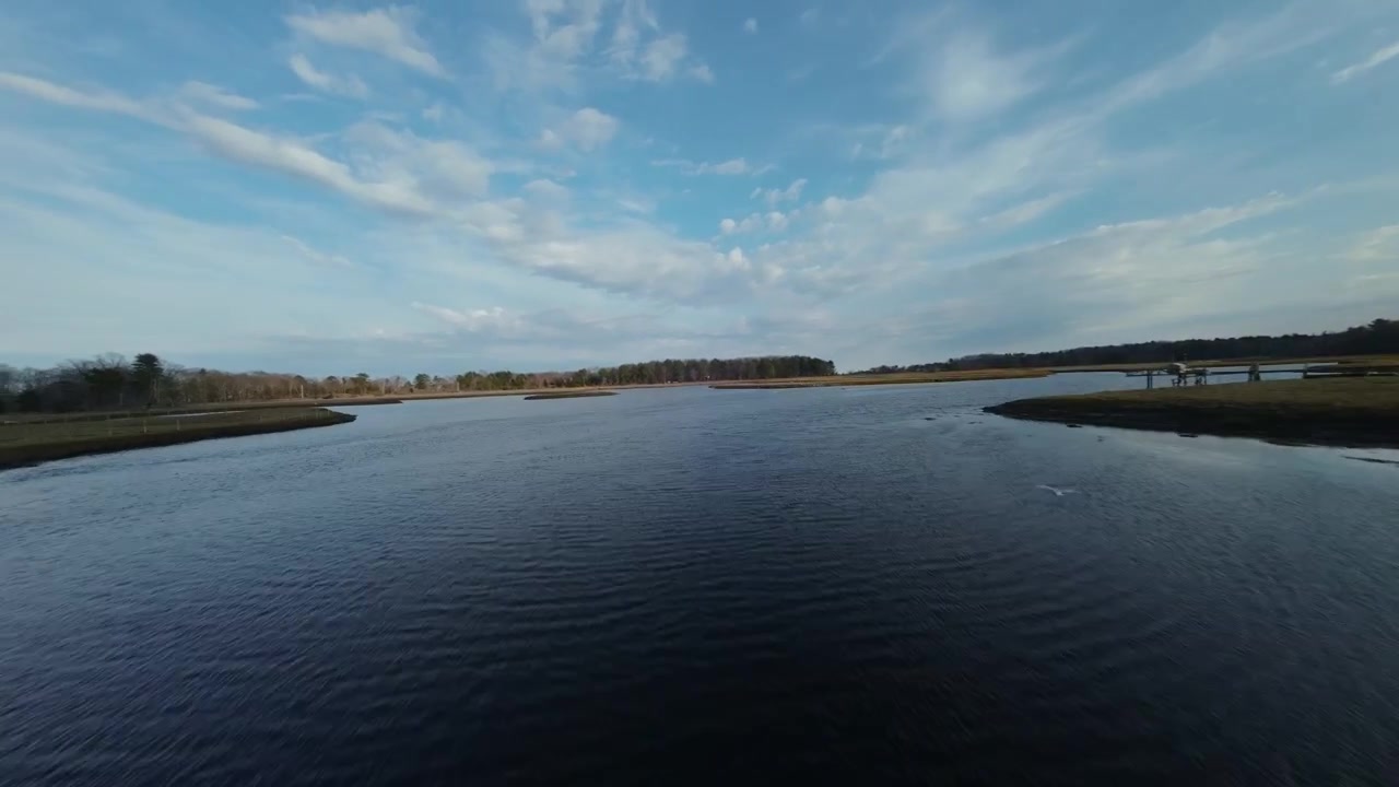Fast-paced FPV drone flying under a bridge on a New Hampshire river