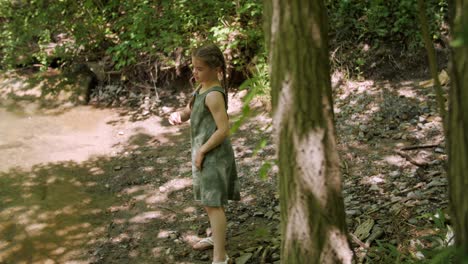 Niña-Arrojando-Una-Piedra-A-Un-Estanque