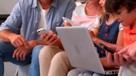 familia que utiliza portátiles, tabletas y teléfonos inteligentes