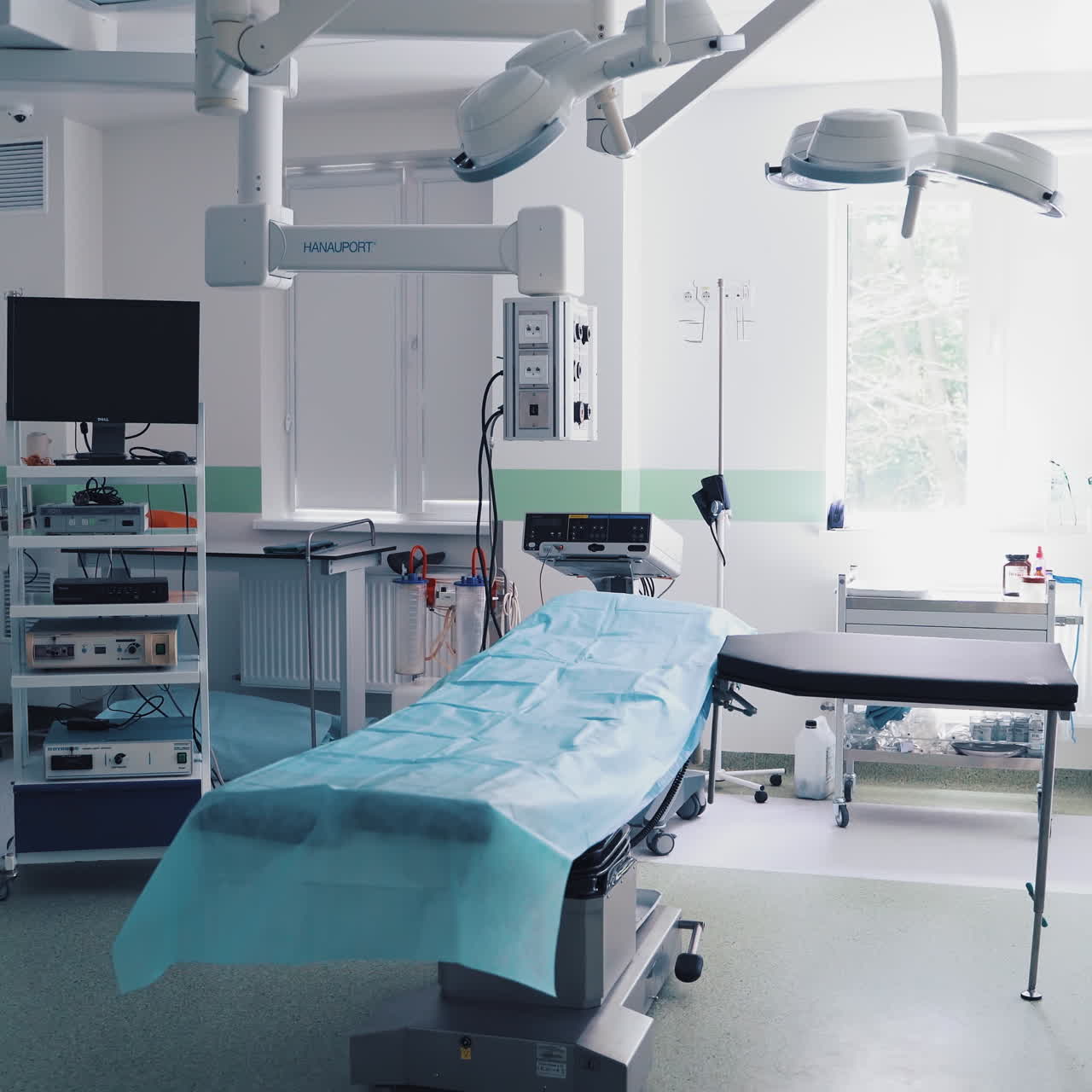 Light operating room with modern equipment in a private clinic. Modern clean and tidy cabinet with special outfit for operations without people inside the hospital.