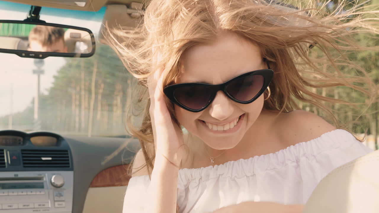 mujer feliz conduciendo un descapotable en un día soleado