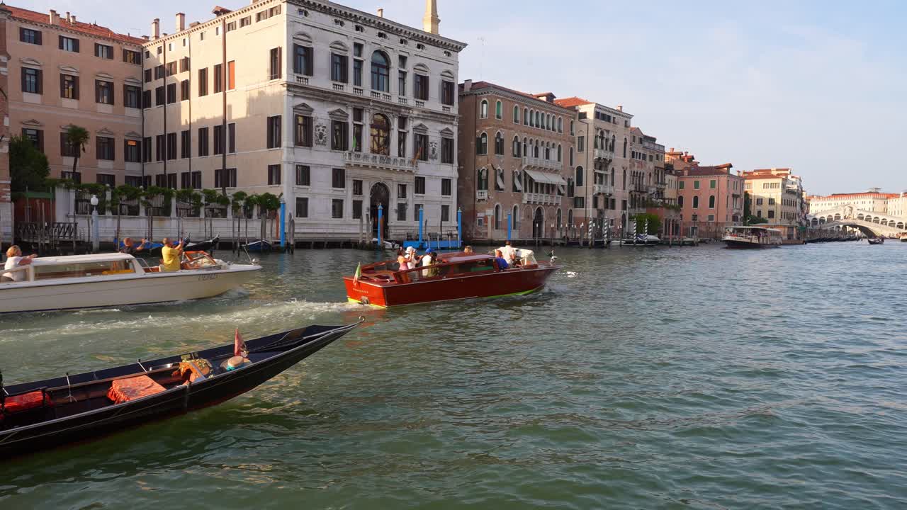 Boats move through the busy Grand Canal in Venice, Italy during the early morning.
