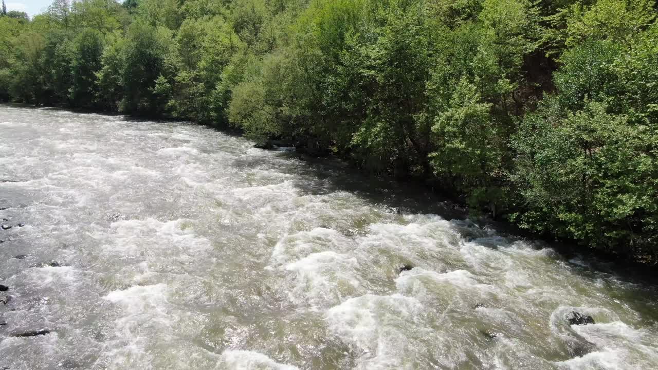 Vista da drone in Albania che sorvola un fiume con rapide impetuose tra montagne verdi in una giornata di sole