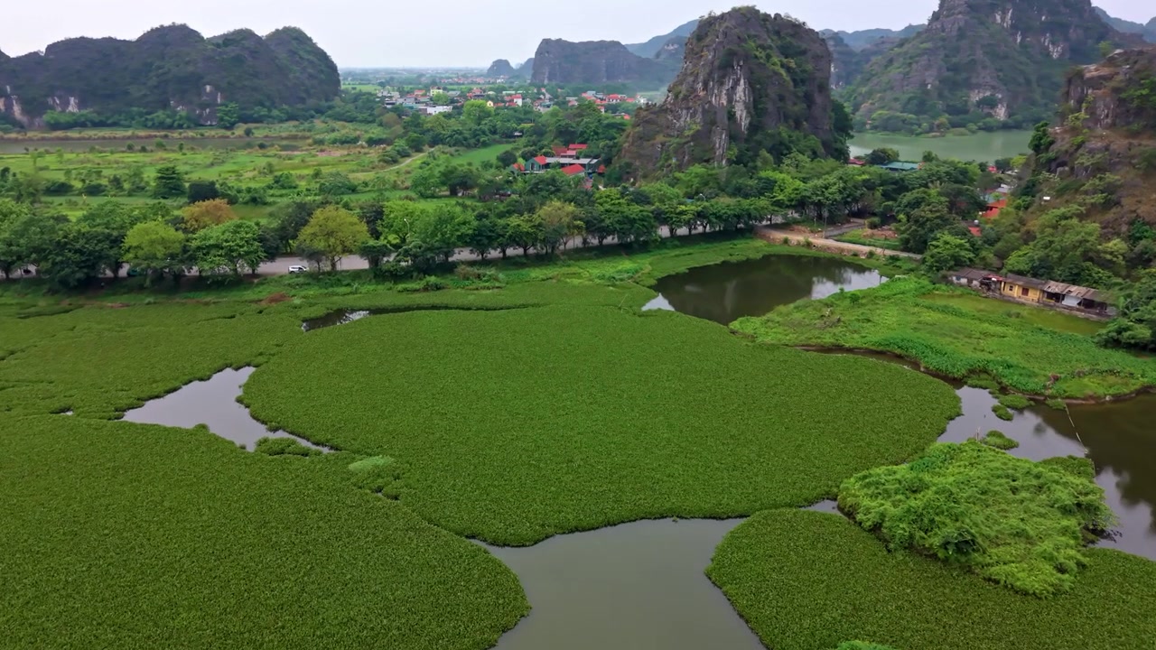 Cảnh quay trên không điện ảnh thể hiện mặt nước đầm lầy yên tĩnh, thảm thực vật xanh tươi rậm rạp và những ngọn núi đá vôi hùng vĩ ở miền Bắc Việt Nam