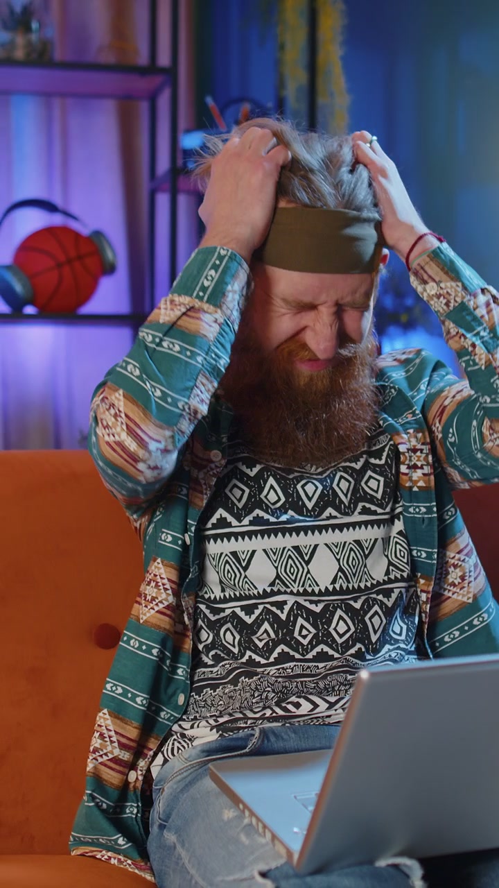 Bearded redhead man use laptop surprised by bad news fortune loss fail lottery results at home