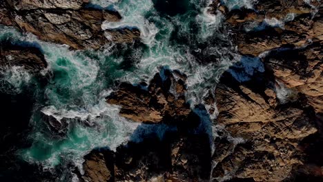 beautiful top down view of waves crashing around rocks during sunset, near big sur, california