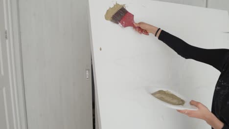 latina painter putting paint on a large canvas in the art studio - medium shot, slow motion