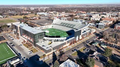 low drone flyover reversing over colorado state university football stadium in the town of fort