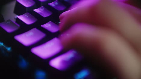 close up hands shot showing a gamer pushing the keyboard buttons while playing an online shooter video game