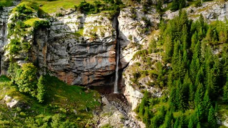 Langsame-Annäherung-An-Einen-Wasserfall,-Der-Sich-Seinen-Weg-Von-Einer-Riesigen-Klippe-Hinunter-Geschnitzt-Hat,-Schöne-Und-Große-Bäume-Umgeben-Die-Landschaft