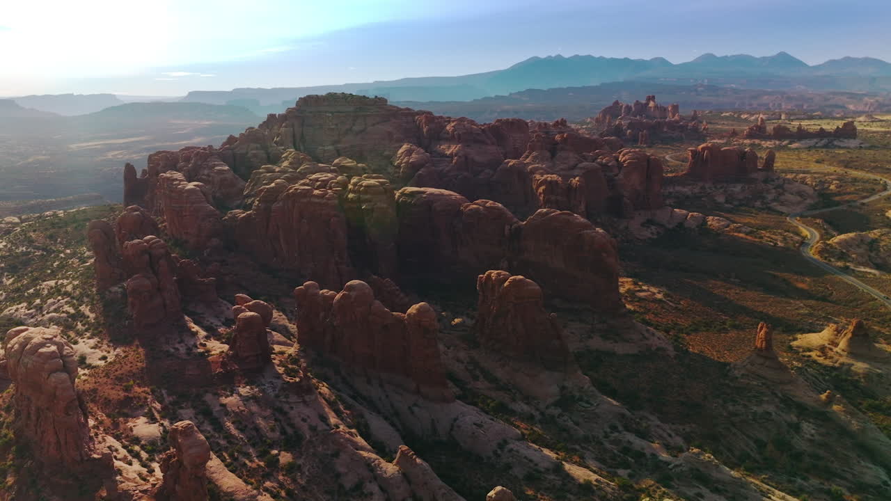 Rounded red rocks in Utah, USA in the rays of bright sun. Arches National Park at the backdrop of blue skies. Aerial view.