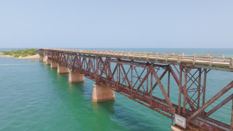 Slow-aerial-shot-along-a-rusted-ocean-bridge-in-Los-Angeles-connecting-an-island