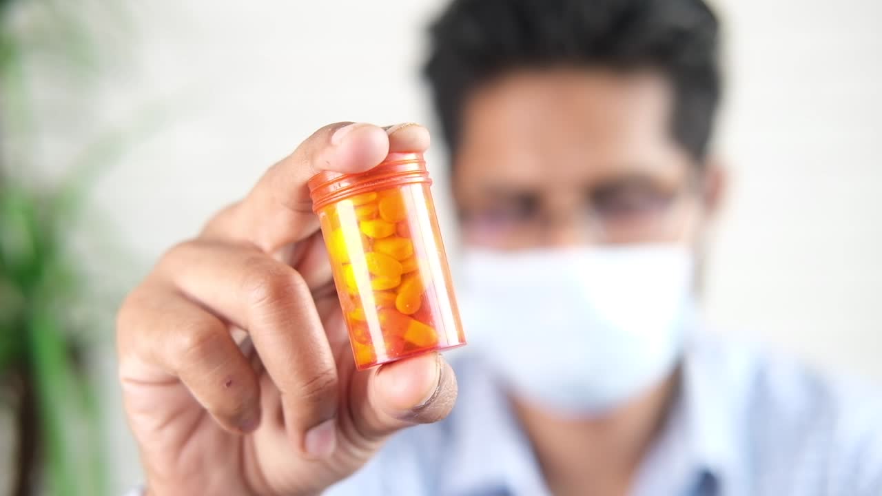 약 을 담은 용기 를 들고 있는 의사