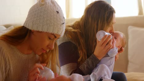 lesbian couple feeding to their baby at home 4k