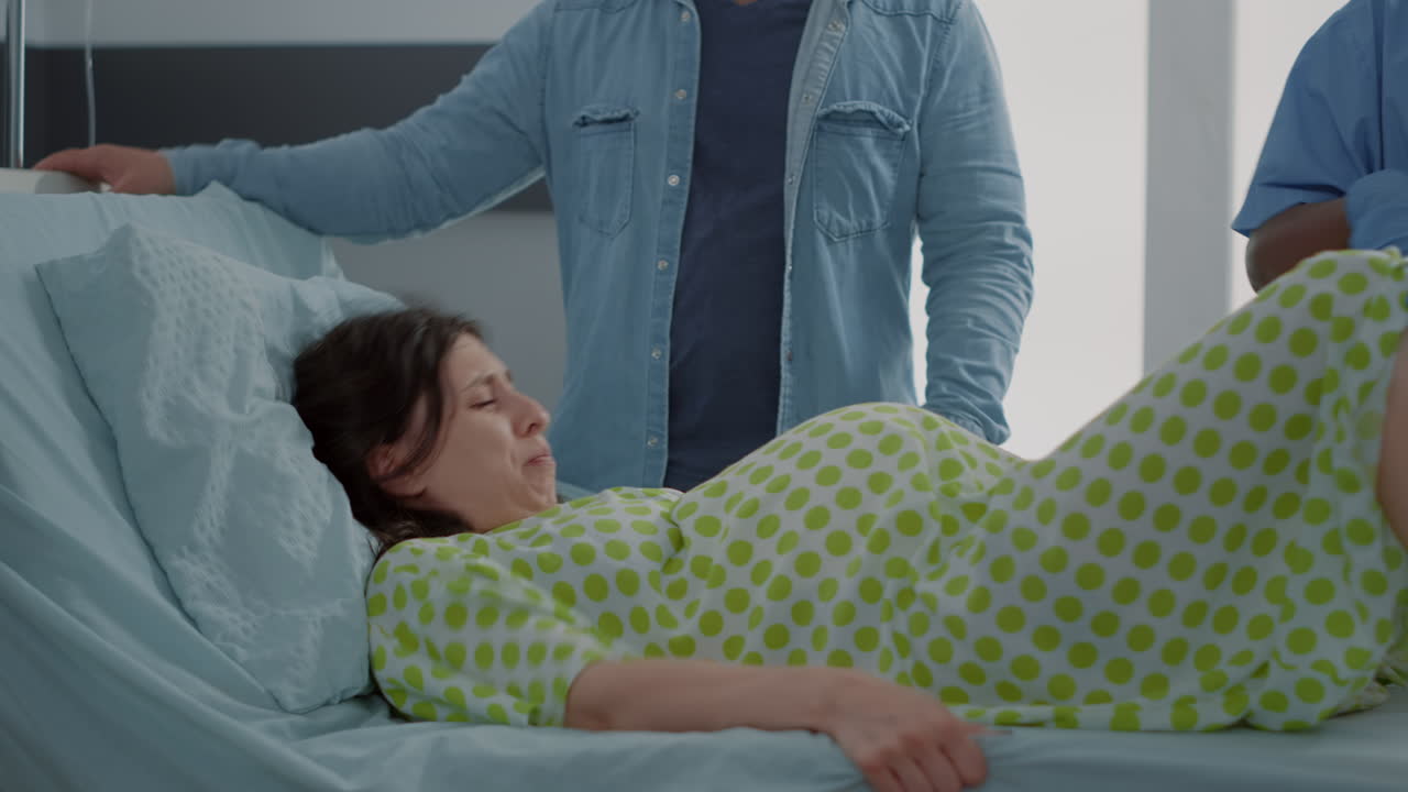 Young woman giving birth at maternity laying in hospital ward