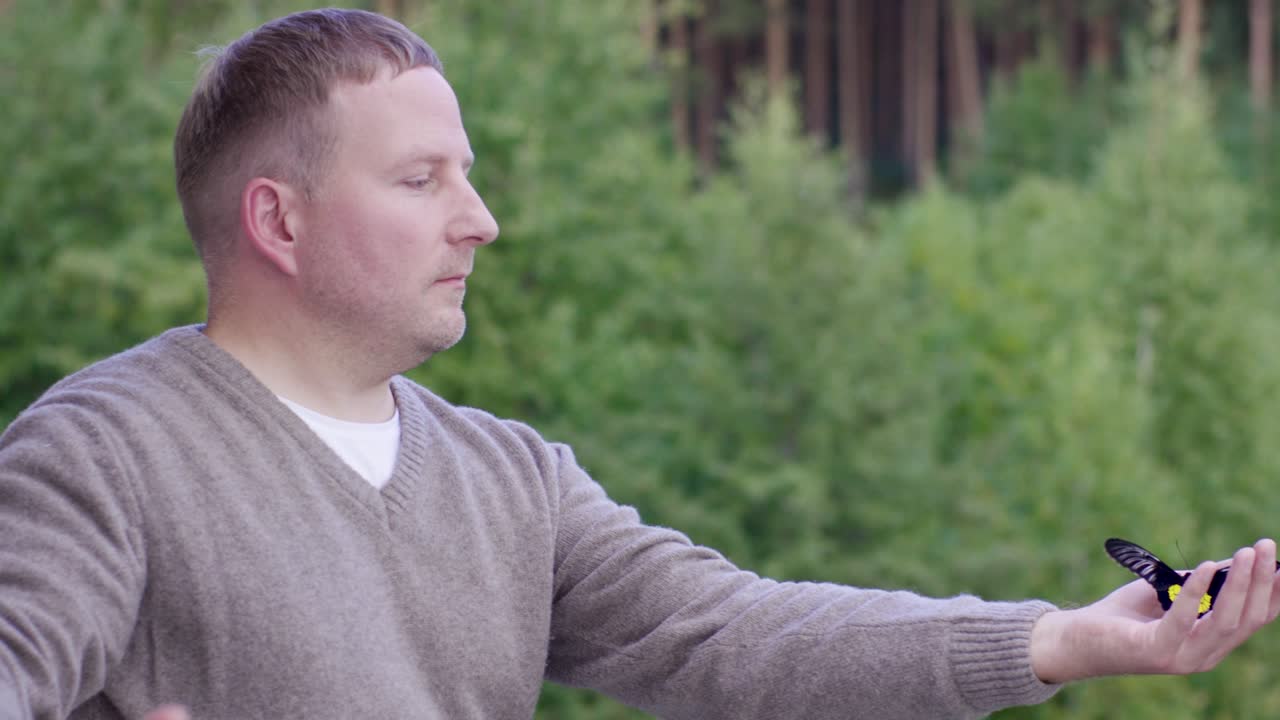 hombre observando una mariposa en el bosque