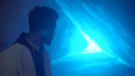 black man looking at spinning light in laser tunnel