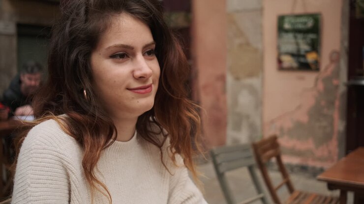 une jeune femme souriant et parlant avec un ami