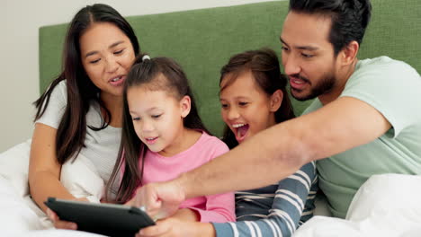 Madre,-Padre-E-Hijos-Con-Una-Tableta-En-La-Cama