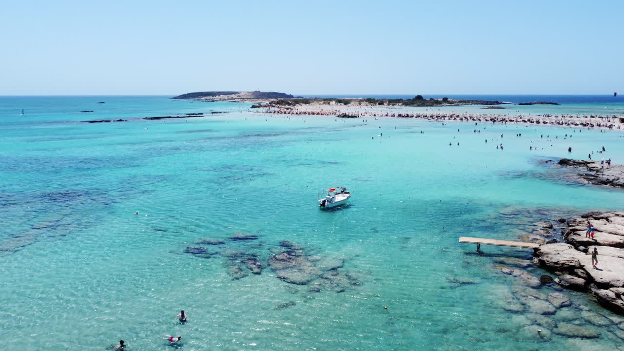 turistas nadando y disfrutando de las claras aguas azules de la playa de elafonissi, creta