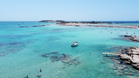 tourists swimming and enjoying clear blue waters of elafonissi beach, crete