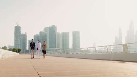 equipo de negocios caminando por el puente en la ciudad de dubai