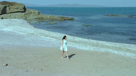 Linda-Chica-Con-Vestido-Blanco-Camina-Por-La-Playa-1