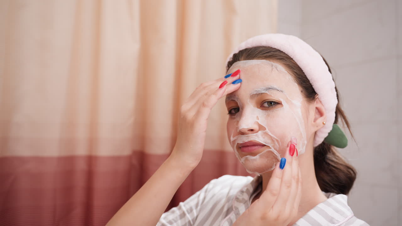 Gentle Facial Application, Woman Softly Massages Serum Onto Face, Lady Delicately Spreads Serum Across Her Facial Skin, Young Woman Uses Tender Rhythmic Movements To Apply Serum Beautifully