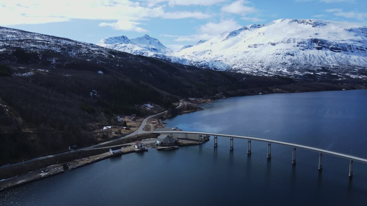impresionante órbita aérea de paisaje montañoso nevado y pintoresco puente arsteinbrua en gratangen, noruega