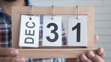 man holding a december 31st calendar