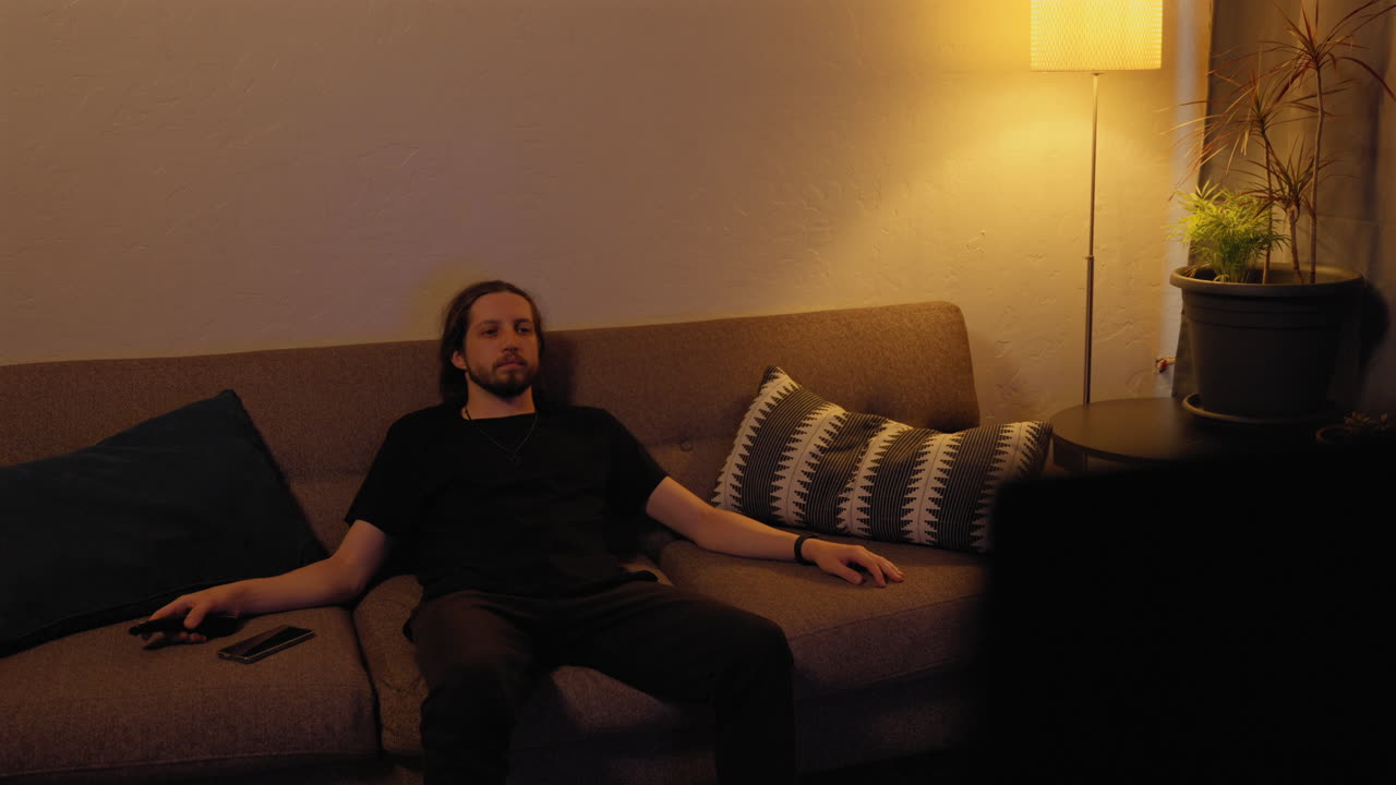 Bearded, Caucasian adult male binge-watching TV finally decides to do something else