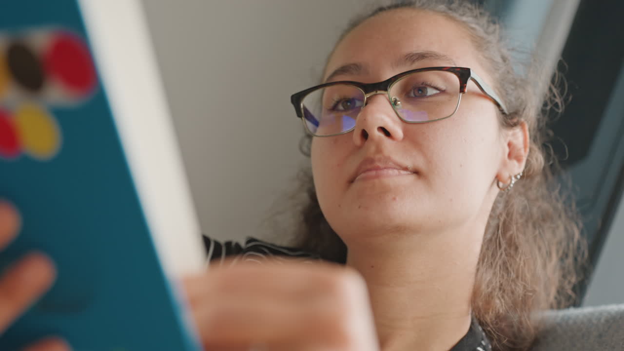 Estudiante revisando apuntes. Mujer concentrada leyendo en el hotel. Mujer dentro de una habitación de hotel inmersa en una sesión de estudio. Joven examinando cuidadosamente sus notas de investigación en un ambiente tranquilo del hotel.