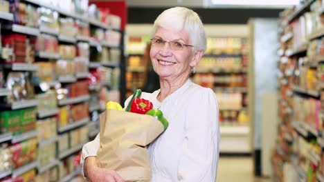 Senior-woman-with-bag-of-veg-in-grocery-store