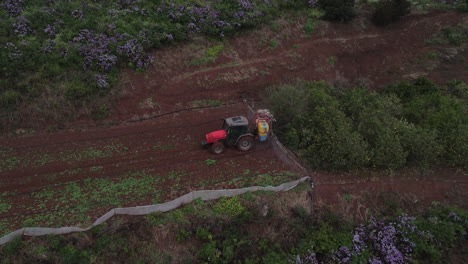 shot of drone in orbit over tractor spraying, potato plantations