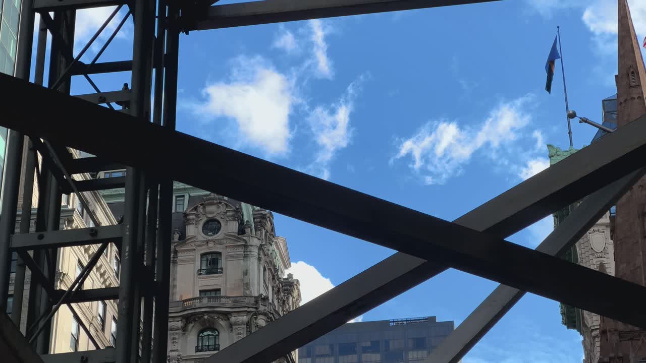 푸른 하늘과 함께 뉴욕의 5번 가로를 가로질러 스카폴딩을 바라보며 지나가는 pov