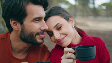 Loving-couple-drinking-beverage-at-picnic-on-nature-closeup.-Romantic-pair-relax