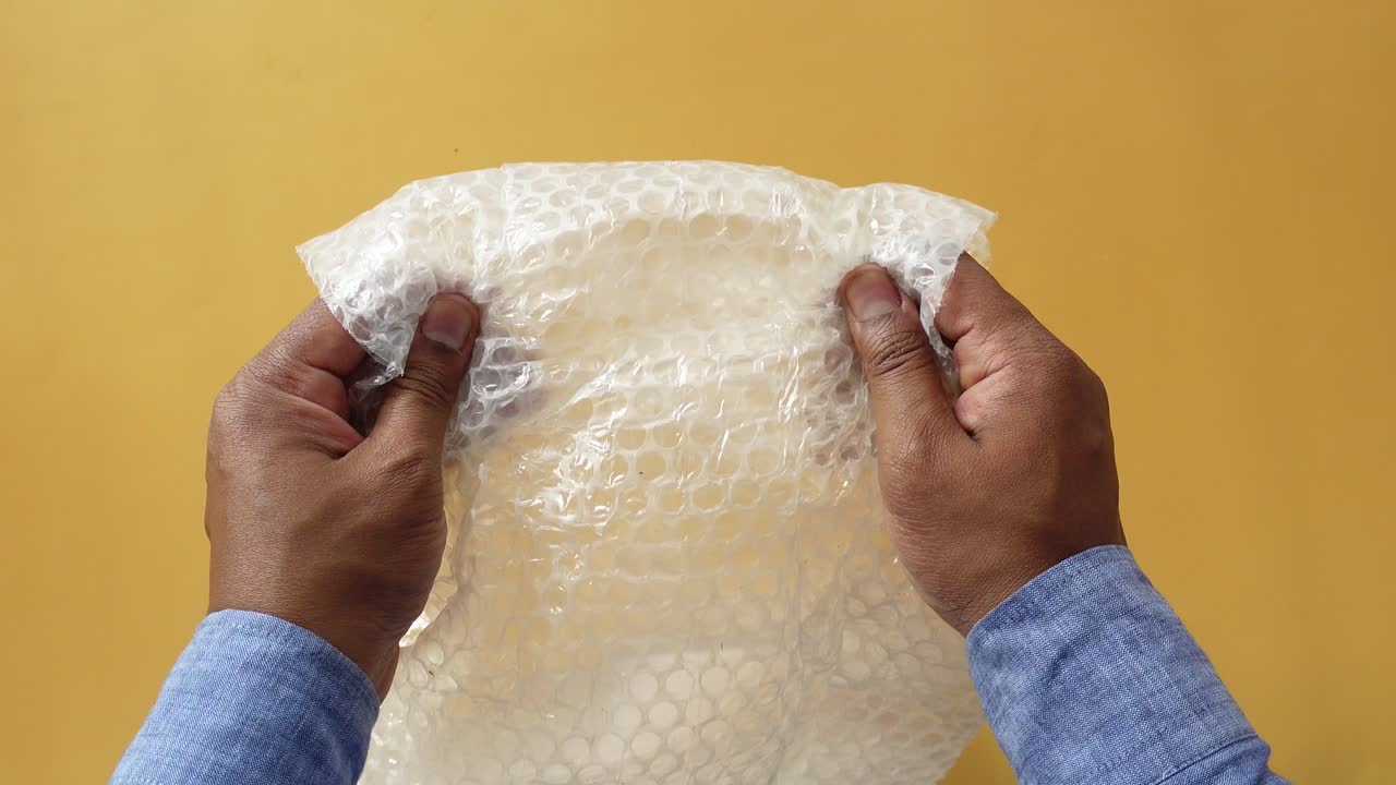 manos con papel de burbuja arrugado